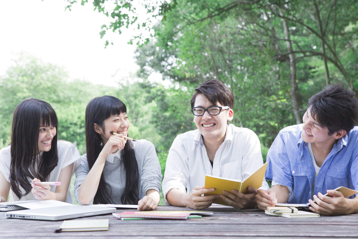 外で談笑する大学生