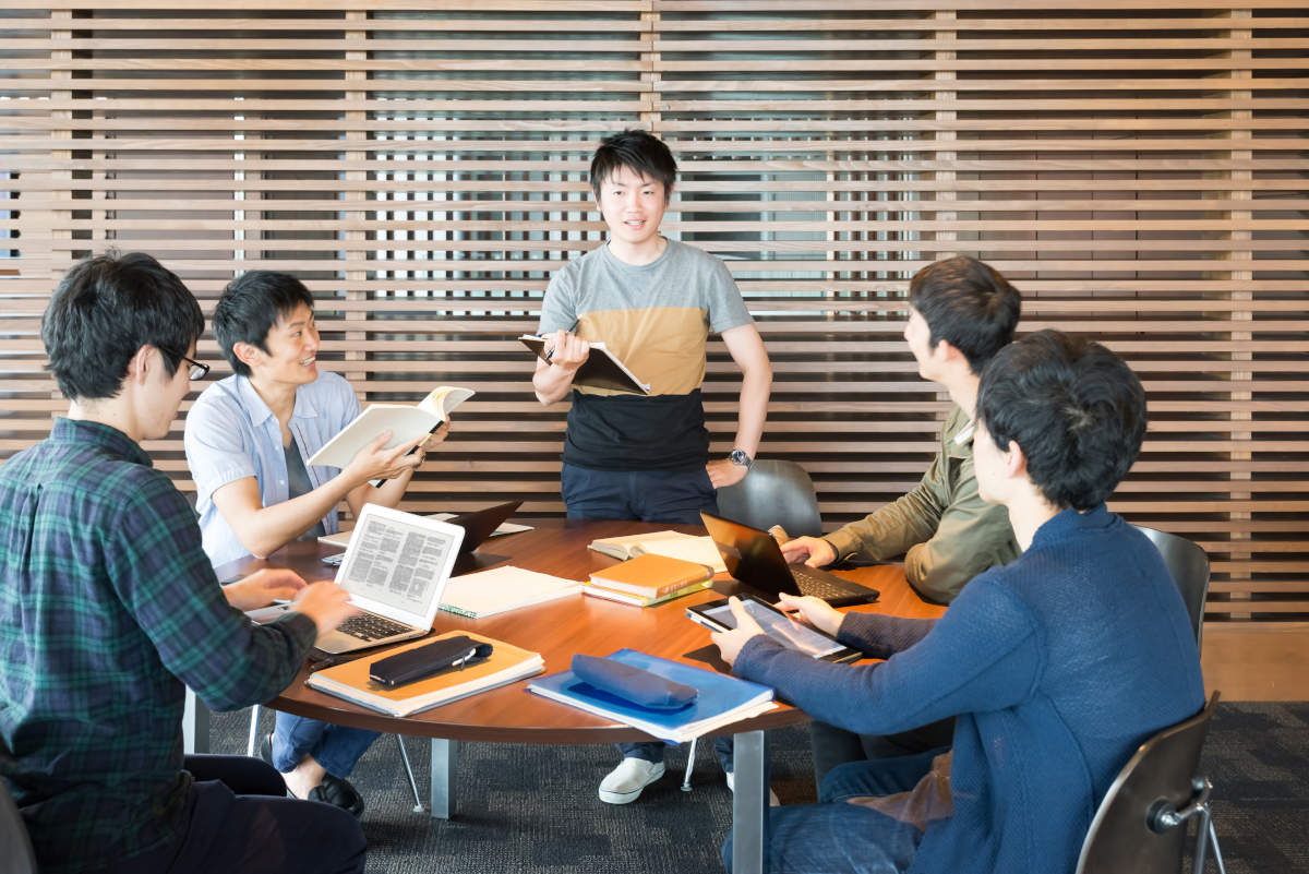 皆の前で発表する男性